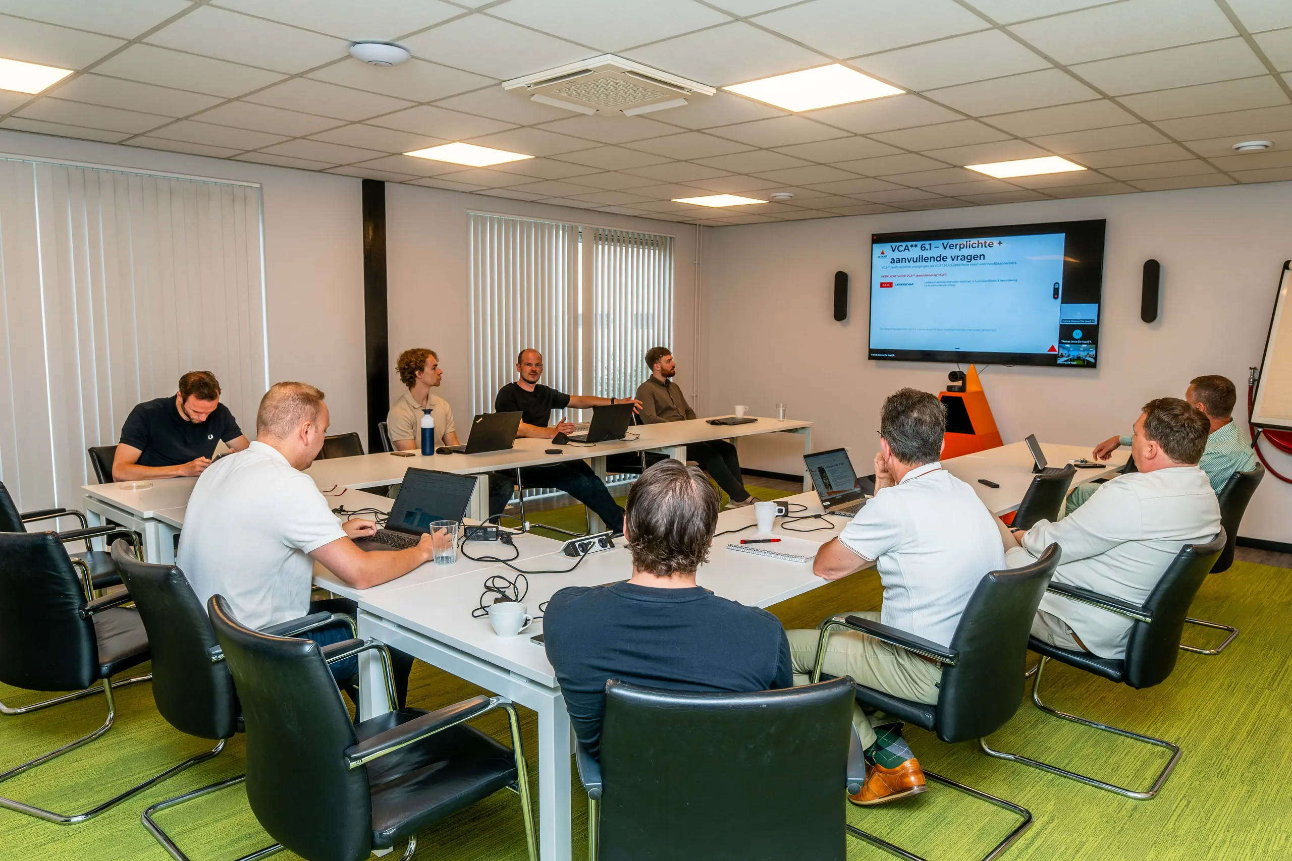 Het team van De Vaart bekijkt een presentatie tijdens het teamoverleg