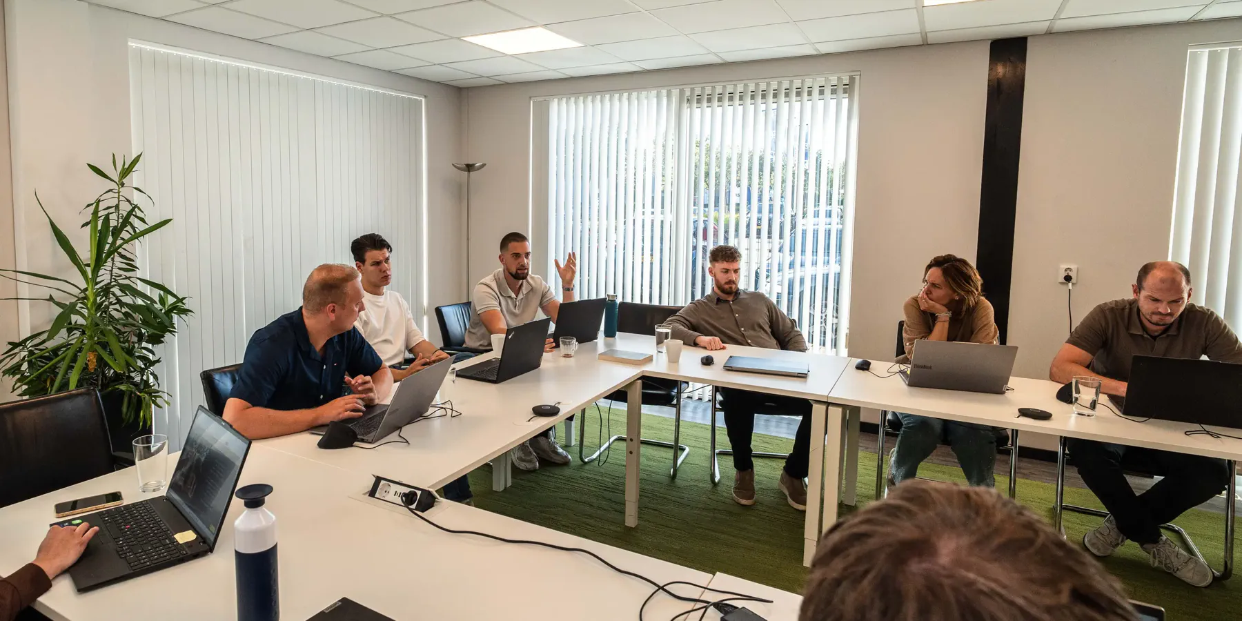 adviseur-aan-het-woord-iso-certificering-de-vaart-hero Adviseur van De Vaart aan het woord tijdens het teamoverleg over ISO-certificering in de vergaderzaal